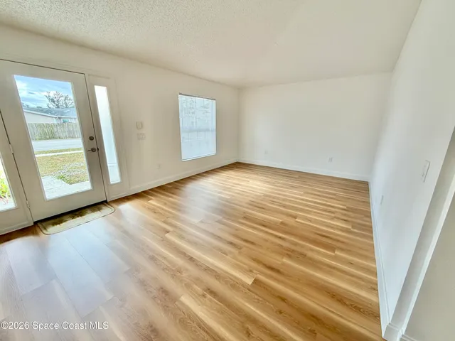 a view of empty room with wooden floor