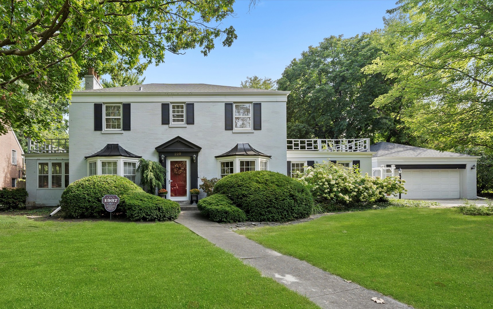 a front view of a house with a garden