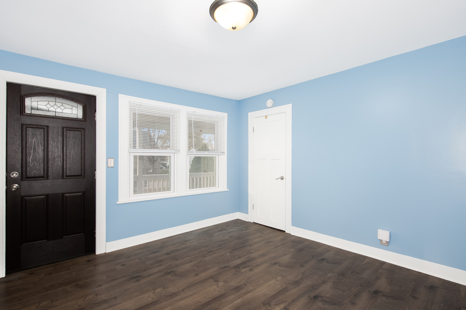 718 Clinton Street Lockport, IL 60441 - Photo 3 of 15 an empty room with wooden floor and windows