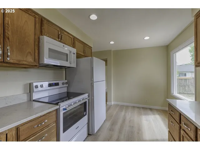a kitchen that has a lot of cabinets in it and wooden floors