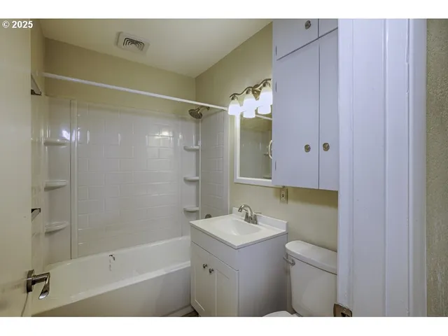 a bathroom with a sink mirror and a shower
