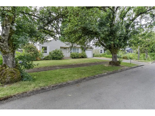 a front view of a house with a yard and trees