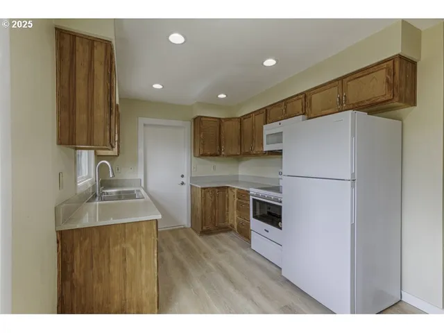 a kitchen with a refrigerator sink and cabinets