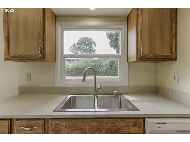a kitchen with a window sink and cabinets