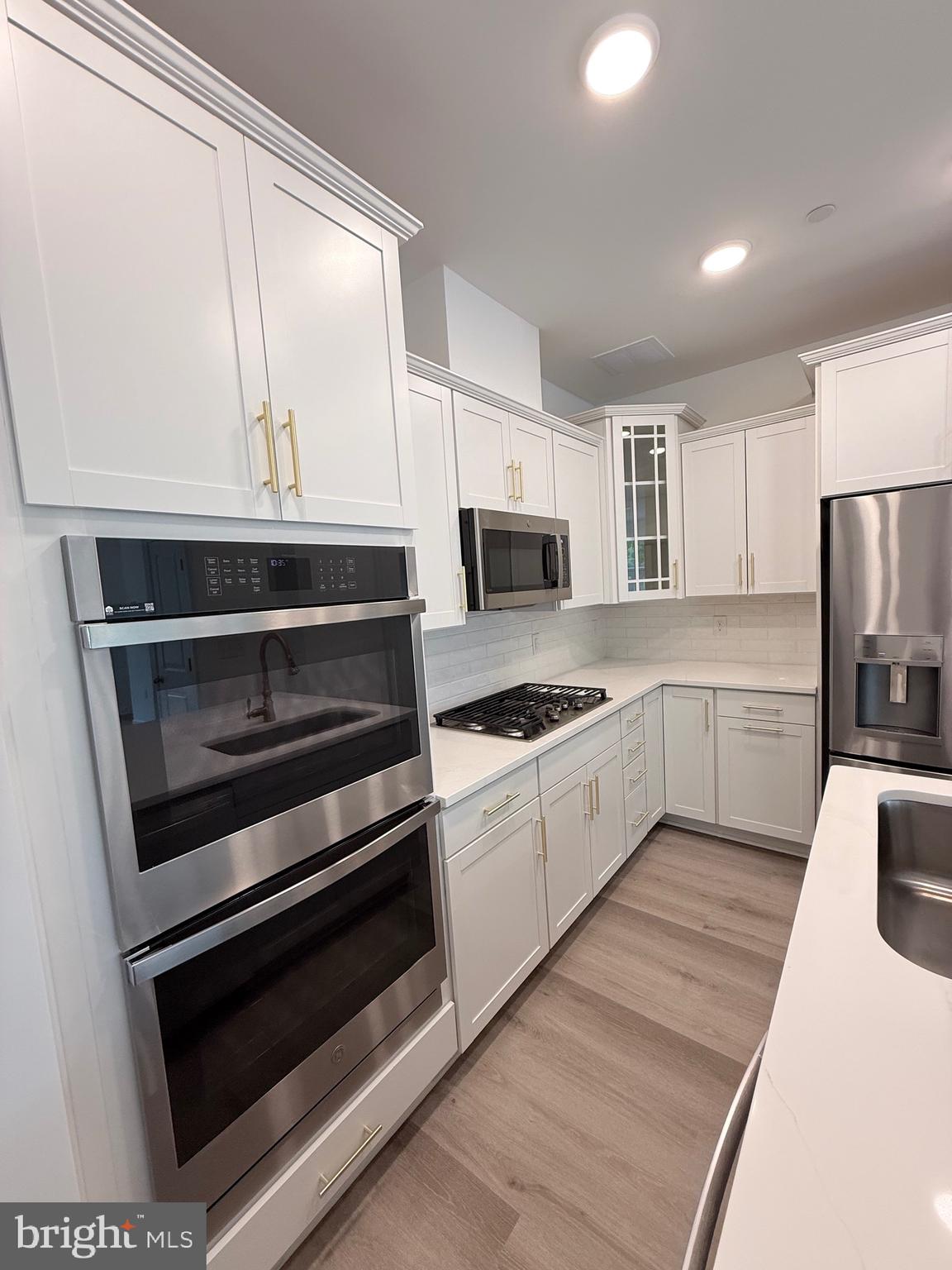 4900 Chelan Crossing Chantilly, VA 20151 - Photo 7 of 27 a kitchen with stainless steel appliances kitchen island granite countertop a stove a sink and a microwave