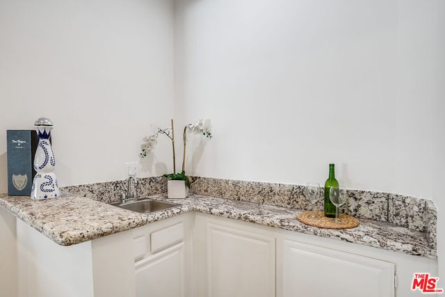 a bathroom with a granite countertop sink and a white cabinets