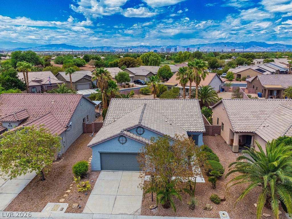 3591 Driving Range Street Las Vegas, NV 89122 - Photo 1 of 79 An aerial view showcases a residential neighborhood under a bright blue sky.