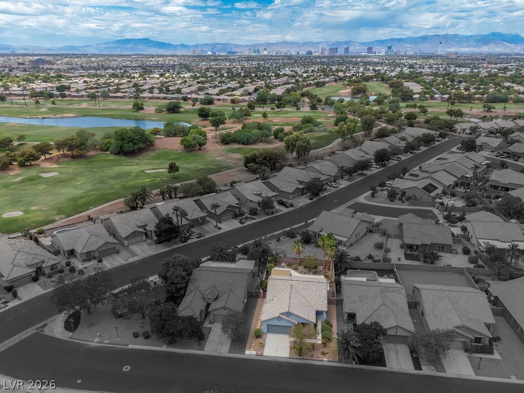 3591 Driving Range Street Las Vegas, NV 89122 - Photo 14 of 79 This aerial view showcases a desirable home near a golf course with city lights in the distance.