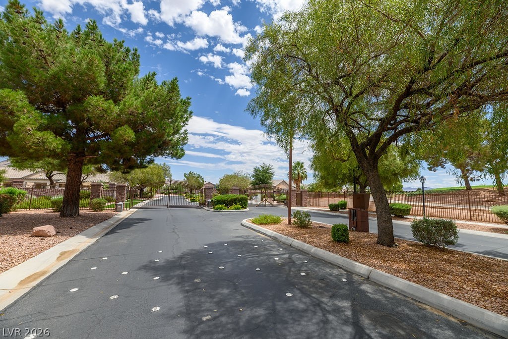3591 Driving Range Street Las Vegas, NV 89122 - Photo 15 of 79 Secure community entrance with lush trees, welcoming you home.