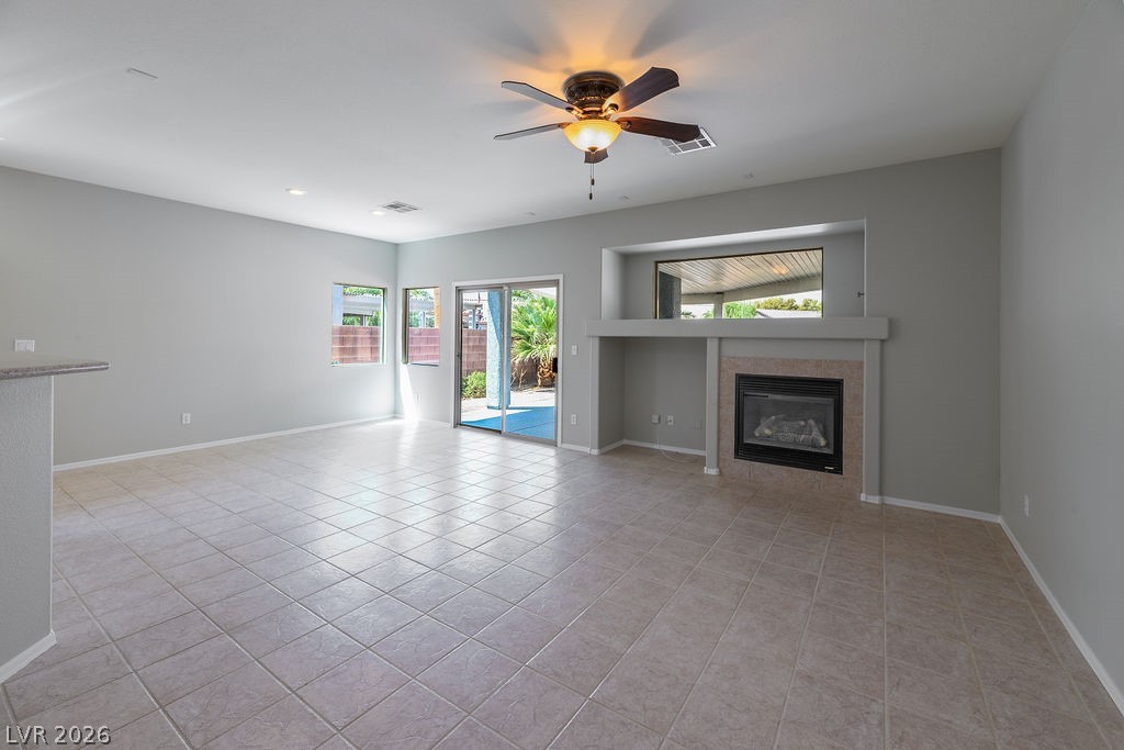 3591 Driving Range Street Las Vegas, NV 89122 - Photo 18 of 79 This bright living space features a fireplace, ceiling fan, and patio access.
