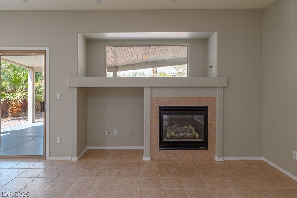 3591 Driving Range Street Las Vegas, NV 89122 - Photo 19 of 79 This living area features a charming fireplace, perfect for cozy evenings, with easy access to outdoor living.