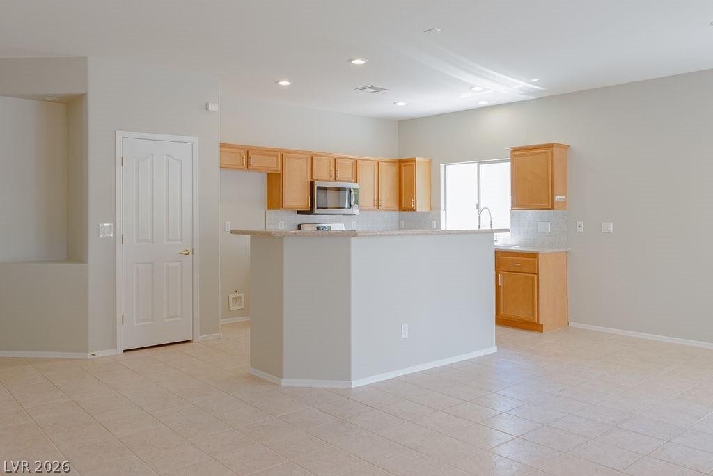 3591 Driving Range Street Las Vegas, NV 89122 - Photo 23 of 79 This spacious kitchen and living area features ample cabinetry and a functional island, perfect for entertaining.