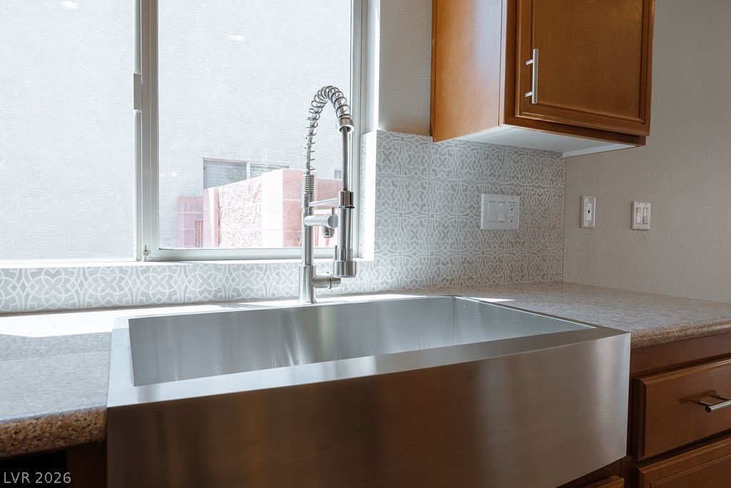 3591 Driving Range Street Las Vegas, NV 89122 - Photo 26 of 79 This bright kitchen features a large stainless steel sink and elegant tile backsplash.
