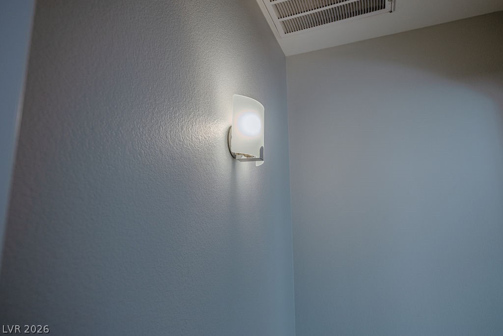 3591 Driving Range Street Las Vegas, NV 89122 - Photo 44 of 79 Bright interior wall light illuminates a textured wall surface, complementing the room's clean lines.