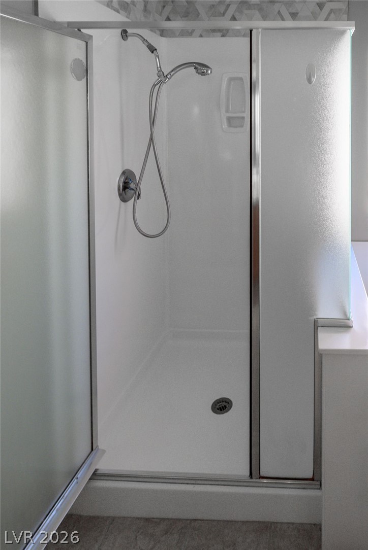 3591 Driving Range Street Las Vegas, NV 89122 - Photo 48 of 79 This modern shower with sleek glass doors offers a refreshing and practical bathing experience.