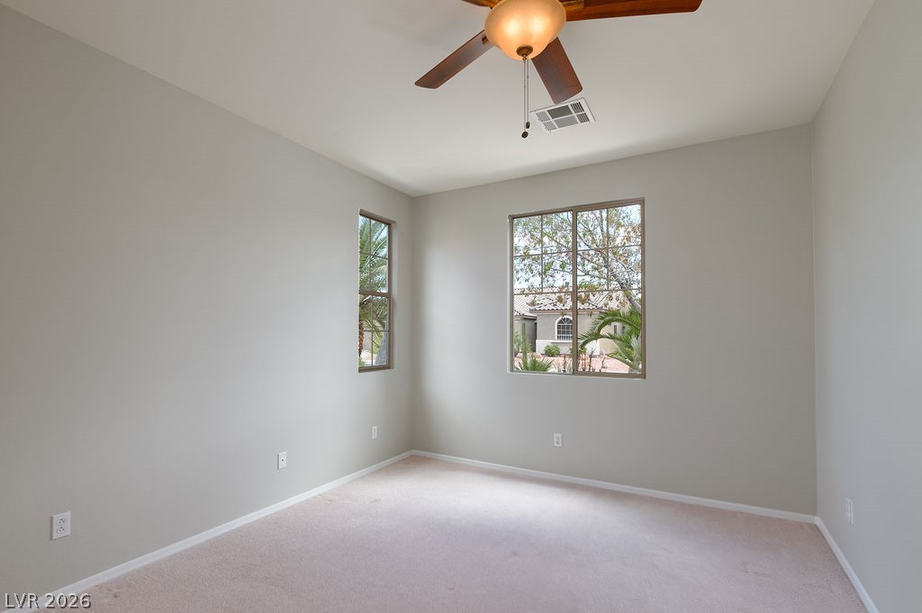 3591 Driving Range Street Las Vegas, NV 89122 - Photo 55 of 79 This airy room features large windows and a ceiling fan, perfect for comfortable living.