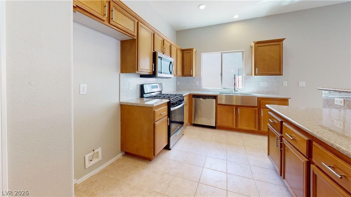 3591 Driving Range Street Las Vegas, NV 89122 - Photo 67 of 79 This bright kitchen features ample cabinetry, stone countertops, and modern stainless steel appliances.