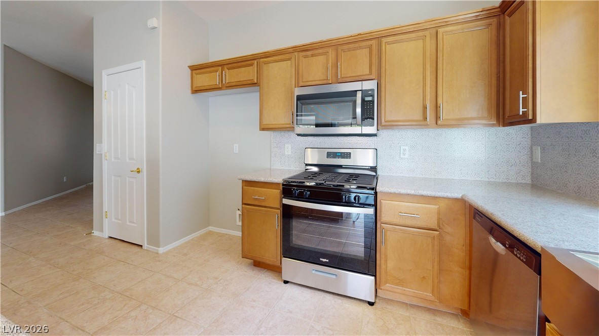 3591 Driving Range Street Las Vegas, NV 89122 - Photo 68 of 79 This kitchen offers functional cabinetry, modern appliances, and durable tile flooring, perfect for daily living.
