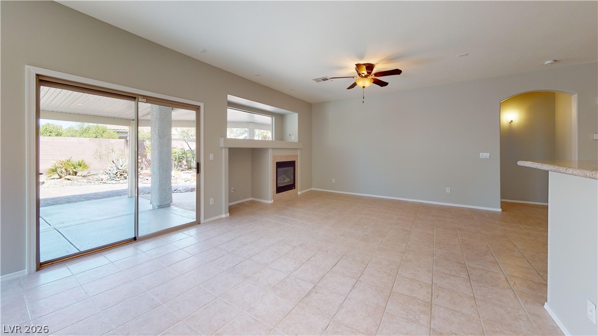 3591 Driving Range Street Las Vegas, NV 89122 - Photo 73 of 79 This airy living space features a fireplace, ceiling fan, and access to the outdoors.