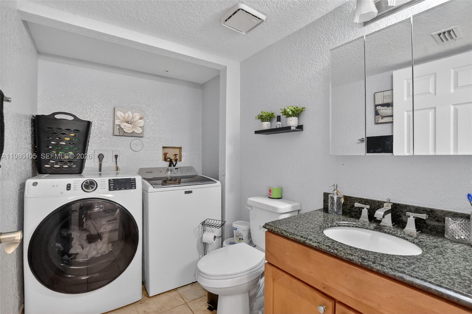 8181 Boca Rio Drive, Unit 8181 Boca Raton, FL 33433 - Photo 14 of 40 a bathroom with a granite countertop toilet a sink and a mirror