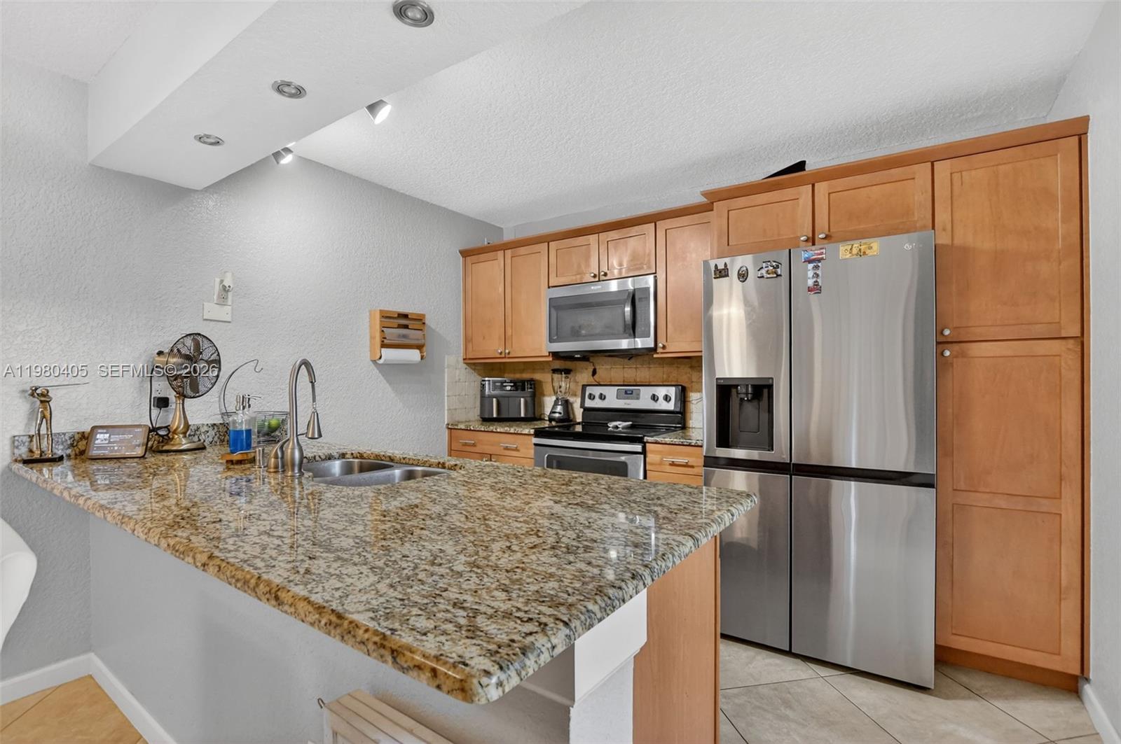 8181 Boca Rio Drive, Unit 8181 Boca Raton, FL 33433 - Photo 17 of 40 a kitchen with refrigerator and microwave