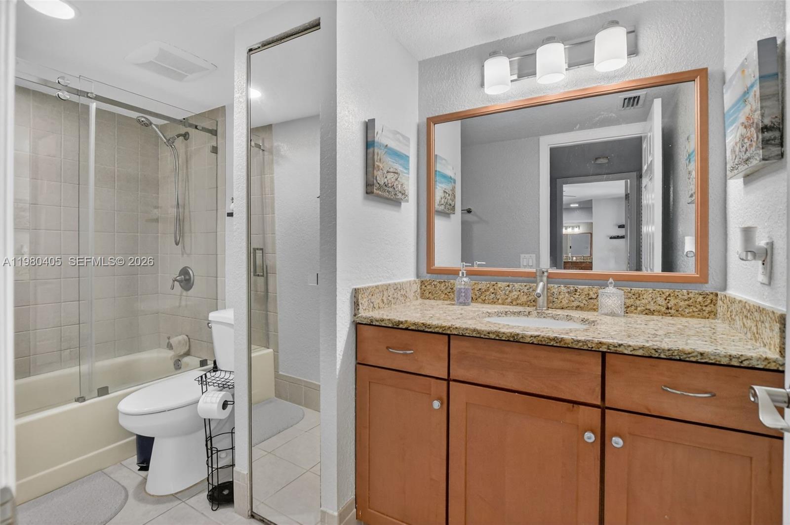 8181 Boca Rio Drive, Unit 8181 Boca Raton, FL 33433 - Photo 27 of 40 a bathroom with a granite countertop sink toilet mirror and a bathtub