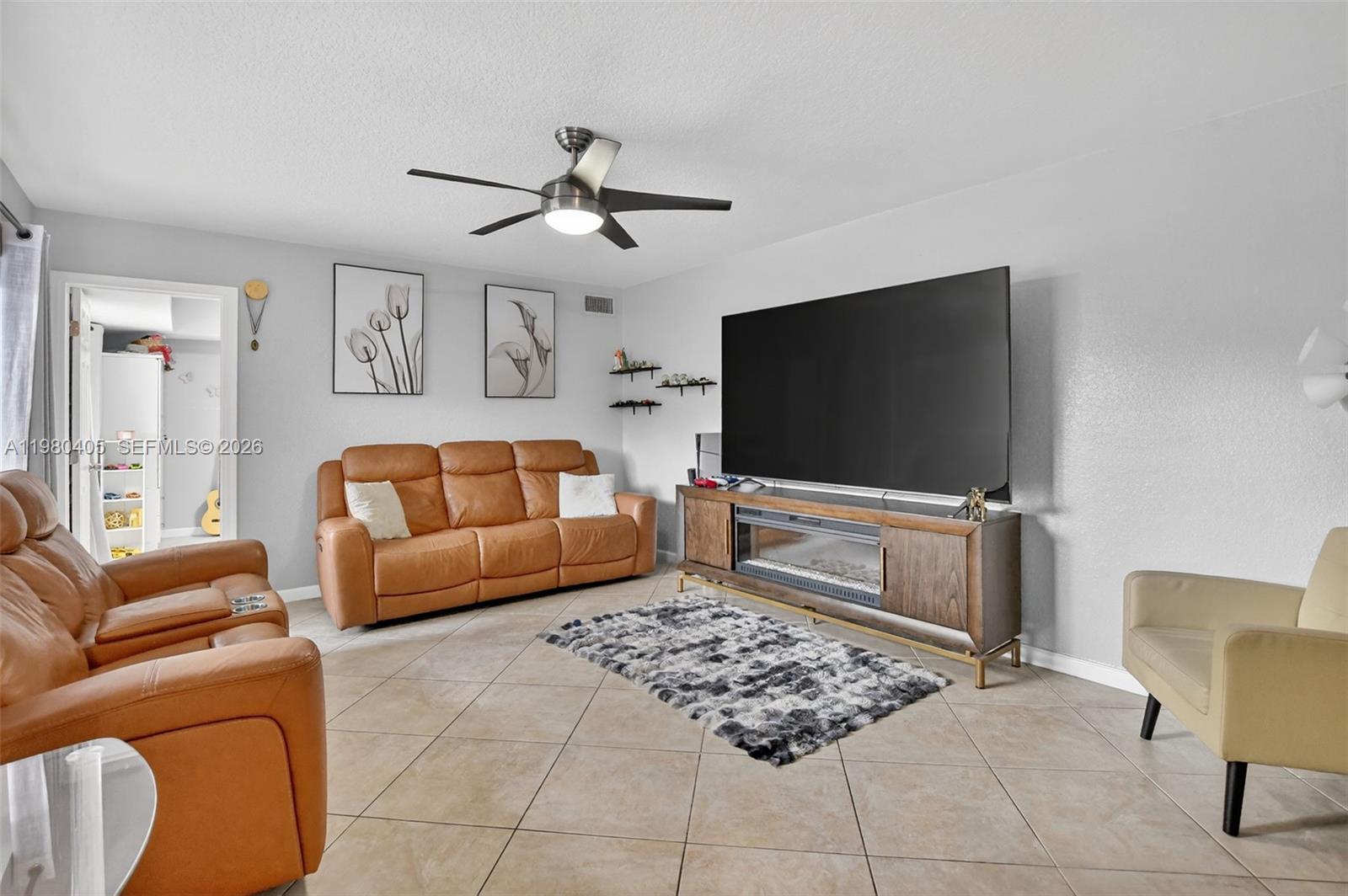 8181 Boca Rio Drive, Unit 8181 Boca Raton, FL 33433 - Photo 4 of 40 a living room with furniture and a flat screen tv