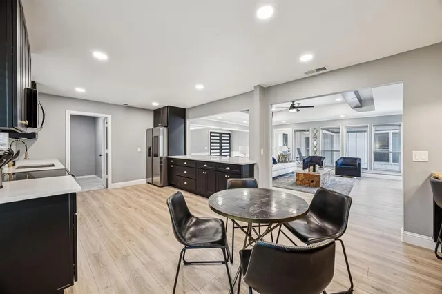 a kitchen with sink refrigerator dining table and chairs