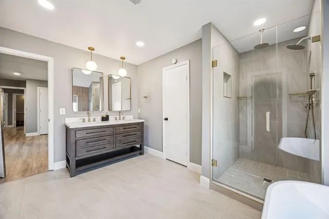 a bathroom with a double vanity sink mirror and shower