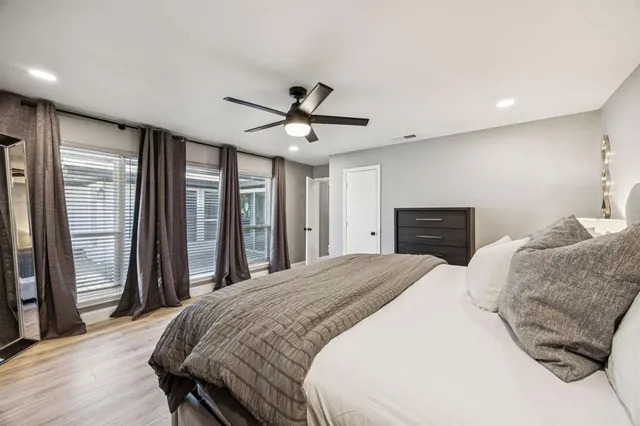 a spacious bedroom with a large bed and a ceiling fan