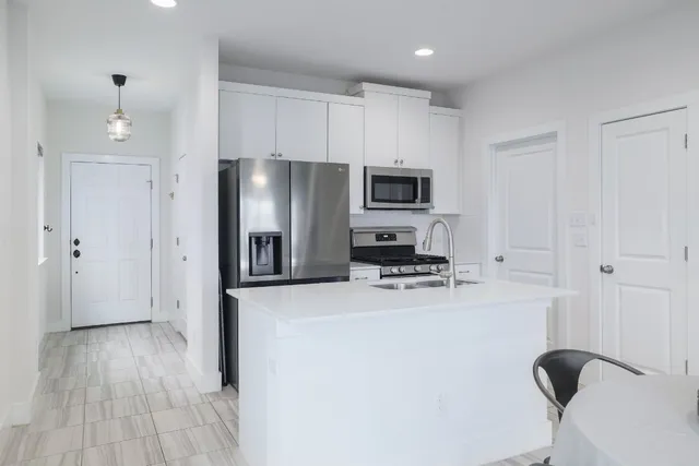 a kitchen with kitchen island a table and chairs in it