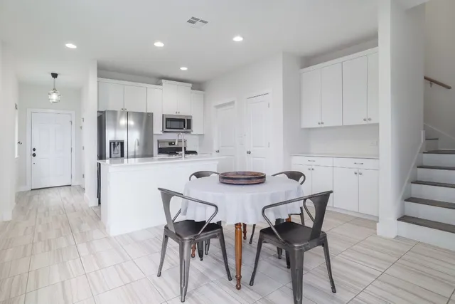 a kitchen with kitchen island a dining table and chairs