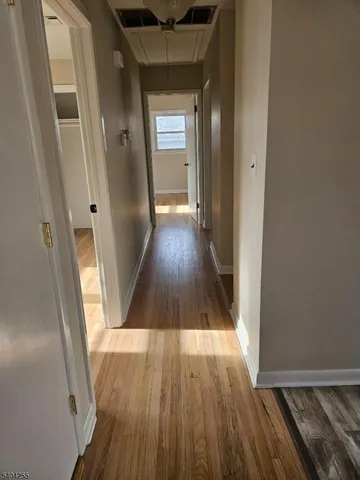 a view of a hallway with wooden floor and staircase