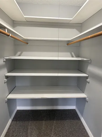 a view of walk in closet with empty racks