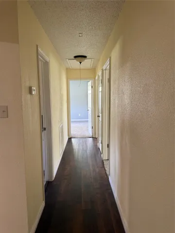 a view of a hallway with wooden floor