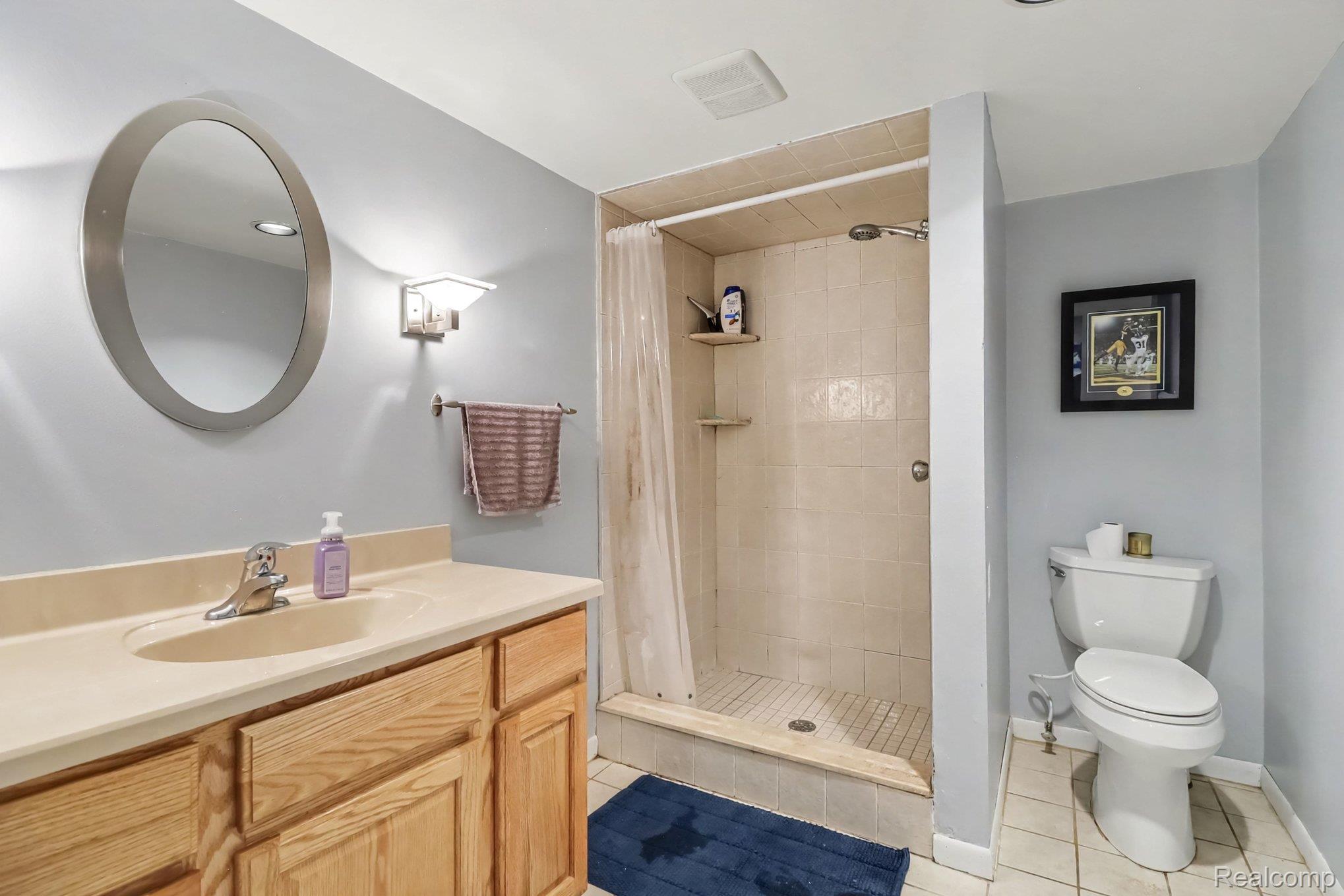 24404 Jamestowne Road Novi, MI 48375 - Photo 18 of 26 Vanity with wood-finish cabinetry, integrated sink, and wall-mounted lighting