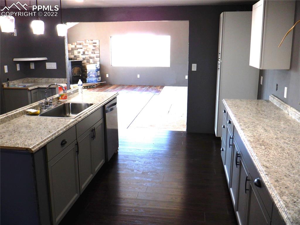 995 Choate Lane Yoder, CO 80864 - Photo 11 of 48 a kitchen with stainless steel appliances granite countertop a sink a stove and a wooden floors