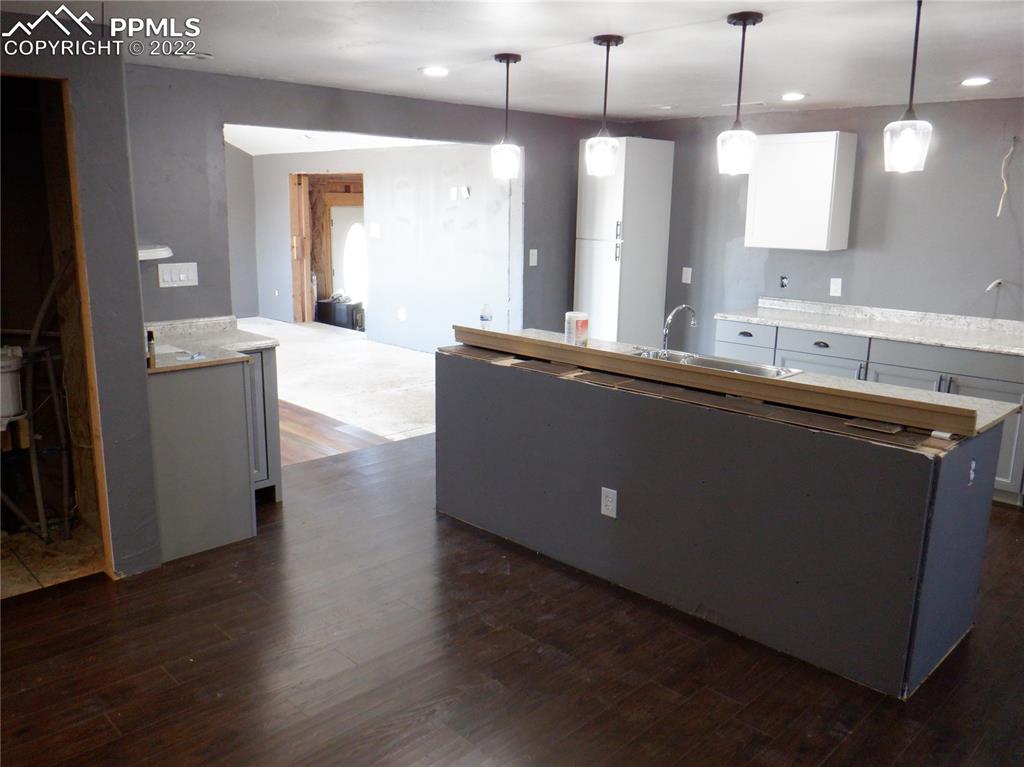 995 Choate Lane Yoder, CO 80864 - Photo 12 of 48 a large kitchen with stainless steel appliances a large counter top a refrigerator a sink and wooden floors