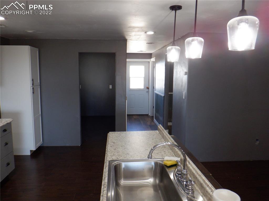 995 Choate Lane Yoder, CO 80864 - Photo 13 of 48 a view of a hallway with entryway wooden floor and front door