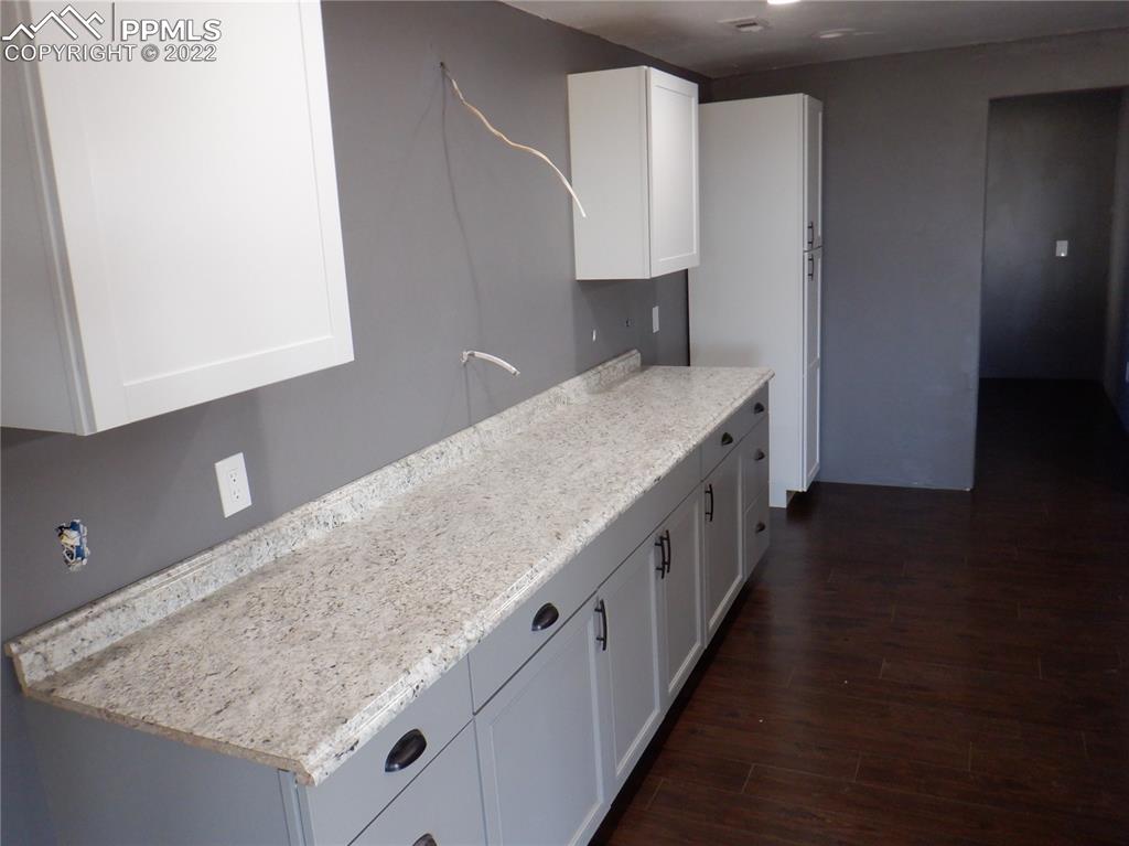995 Choate Lane Yoder, CO 80864 - Photo 15 of 48 a kitchen with granite countertop a sink and a stove
