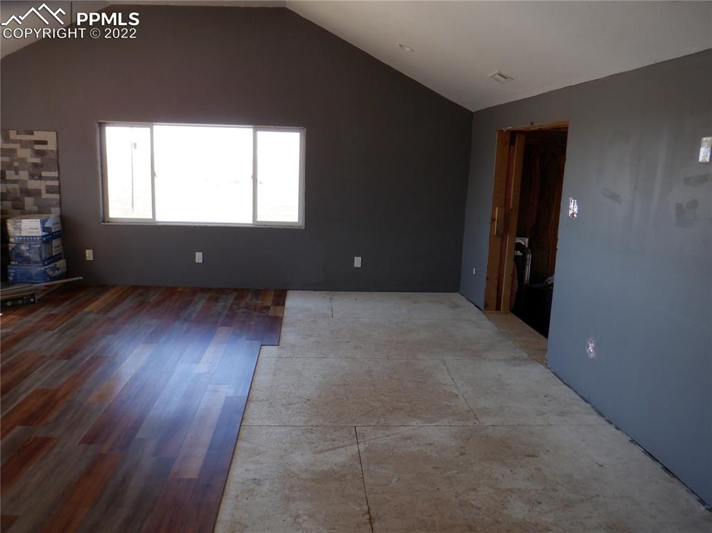 995 Choate Lane Yoder, CO 80864 - Photo 34 of 48 an empty room with wooden floor and windows