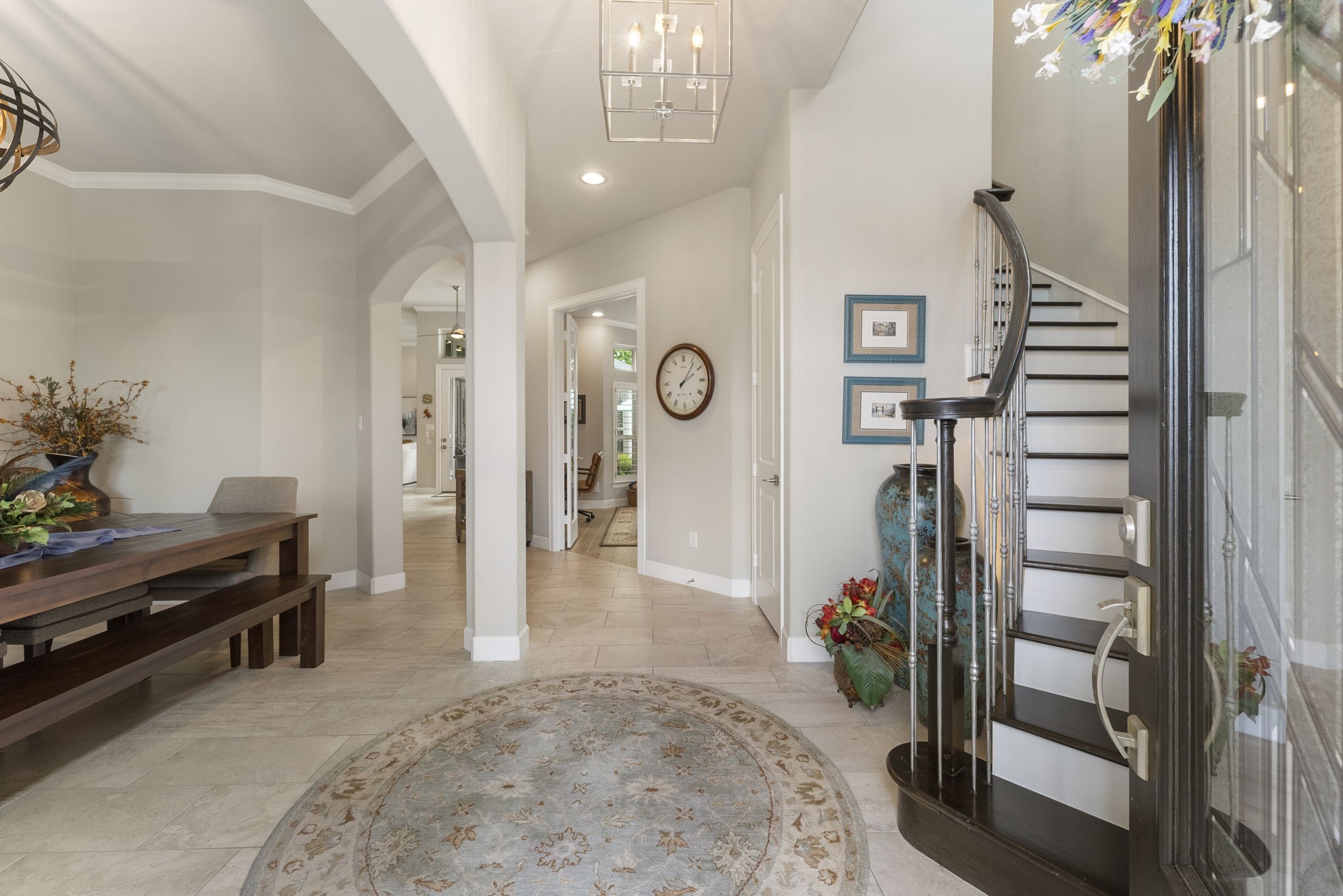 25607 Muirfield Bend Court Spring, TX 77389 - Photo 5 of 30 Light-filled entry showcasing elevated ceilings, refined architectural details, and a striking curved staircase that sets the tone for the thoughtfully designed interiors beyond.