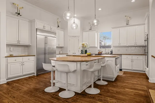 a kitchen with kitchen island granite countertop a sink cabinets and wooden floor