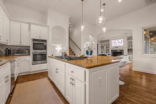 a kitchen with stainless steel appliances granite countertop a sink and a stove top oven