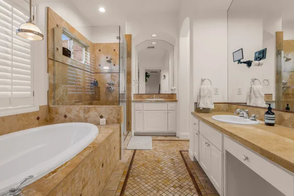 a bathroom with a granite countertop sink mirror bathtub and shower