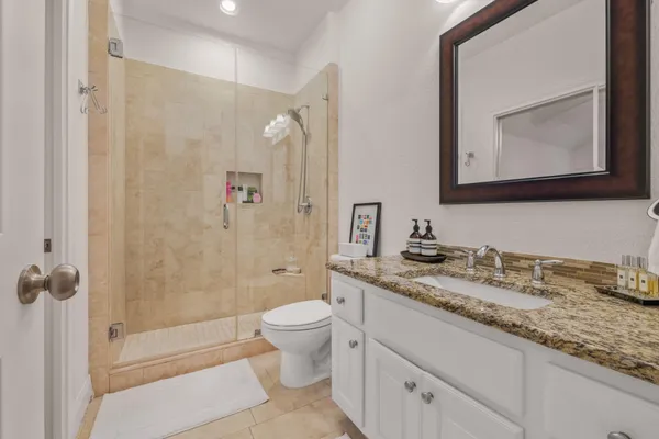 a bathroom with a granite countertop sink toilet and shower