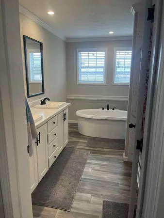 a spacious bathroom with a bathtub sink and mirror