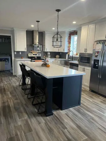 a large kitchen with stainless steel appliances a large center island attached withe living room