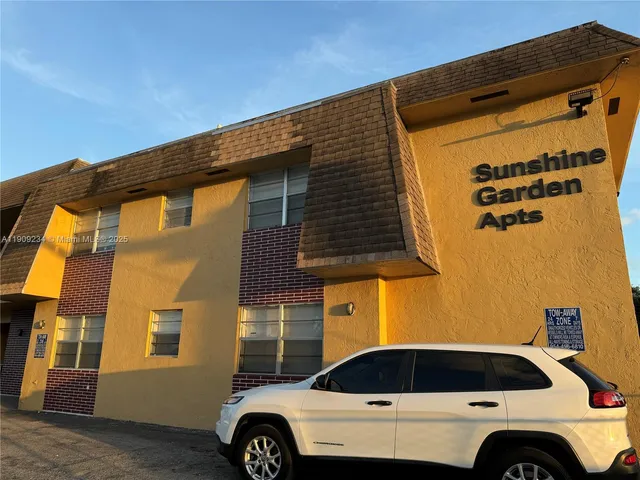 a view of garage with a car parked in front of it