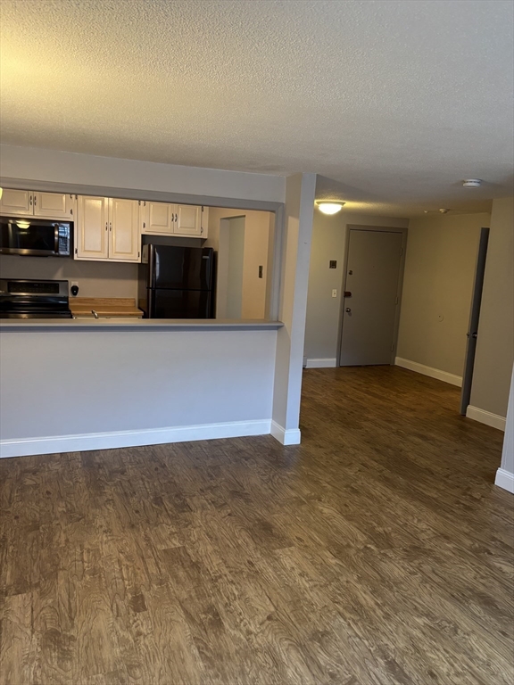 43 Berlin Street, Unit 411 Clinton, MA 01510 - Photo 12 of 14 an empty room with wooden floor and windows